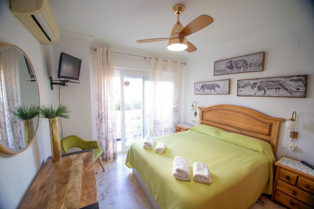 1 dormitorio con 1 cama amarilla y 2 toallas en "El Balcón de Huelva" lujo en pleno centro, en Huelva