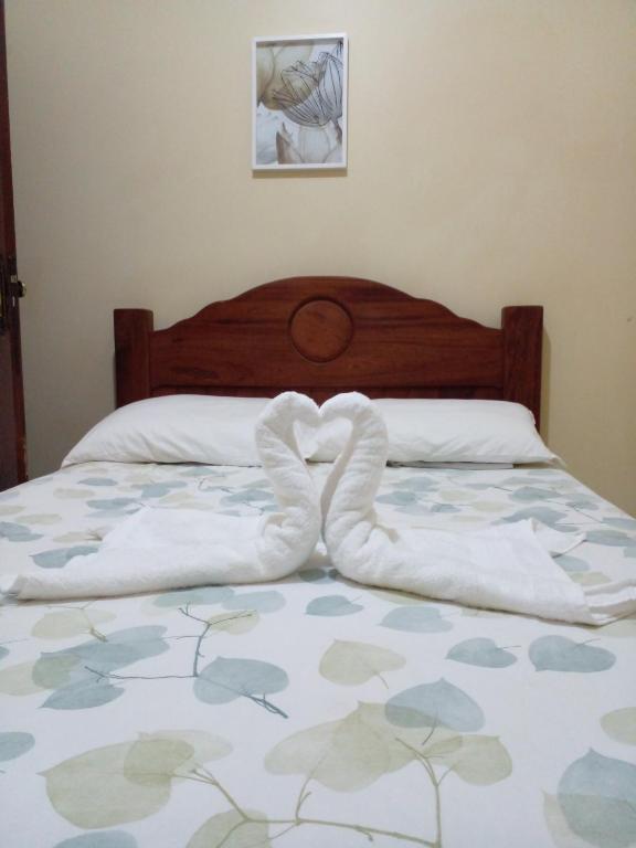 a bed with two towels in the shape of a heart at Pousada Brilho dos Lençóis in Barreirinhas