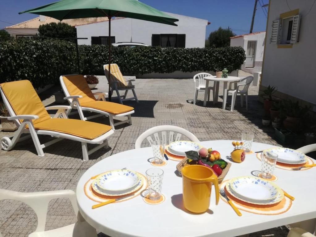 a white table with plates of food on a patio at Casa Oliveirinha - Sagres in Sagres