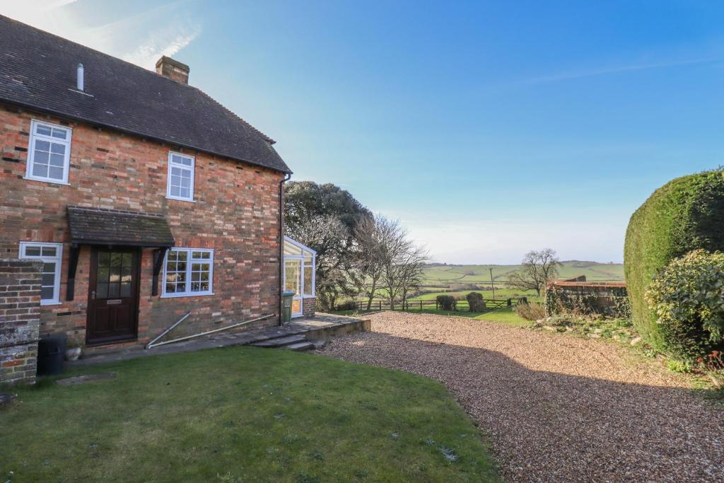 Blick auf ein Backsteinhaus mit Garten in der Unterkunft Orchard Cottage in Ashendon