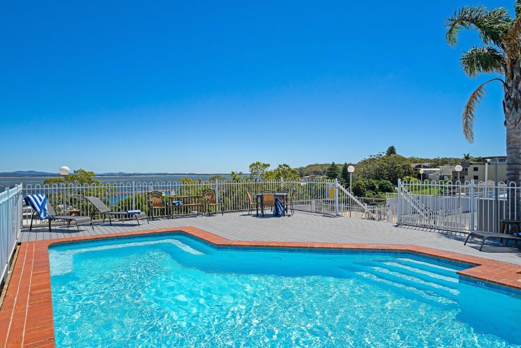 a large swimming pool with a deck at Nelson Towers Motel & Apartments in Nelson Bay