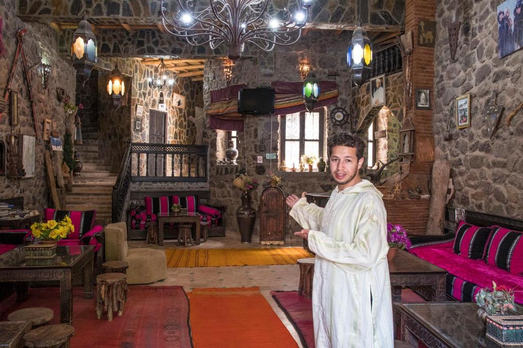 a man in a white robe standing in a room at Riad imlil in Imlil