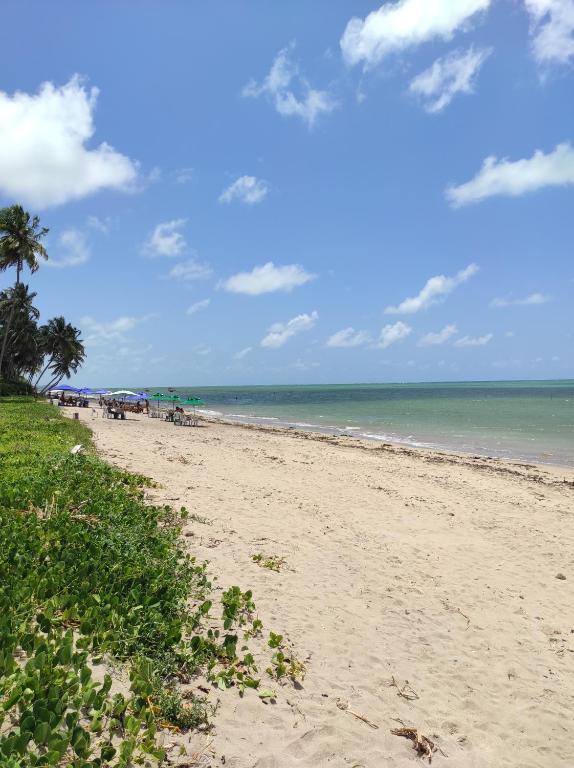 a sandy beach with a view of the ocean at Pousada Sunshine - Praia do Patacho in Pôrto de Pedras