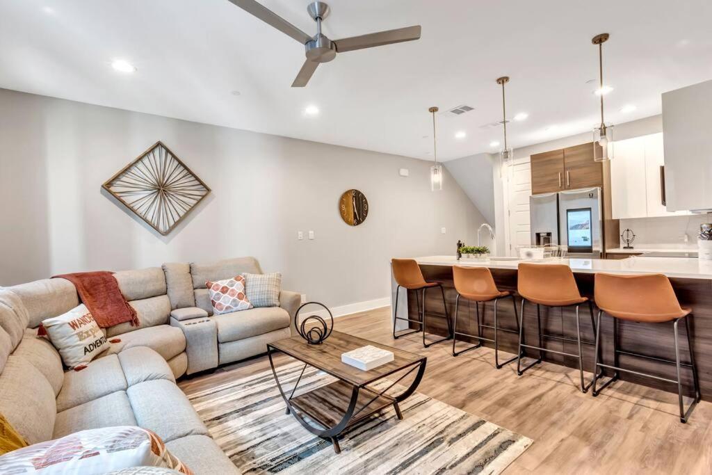 a living room with a couch and a kitchen at Private Rooftop Patio + 4 Story Home in Downtown FW in Fort Worth