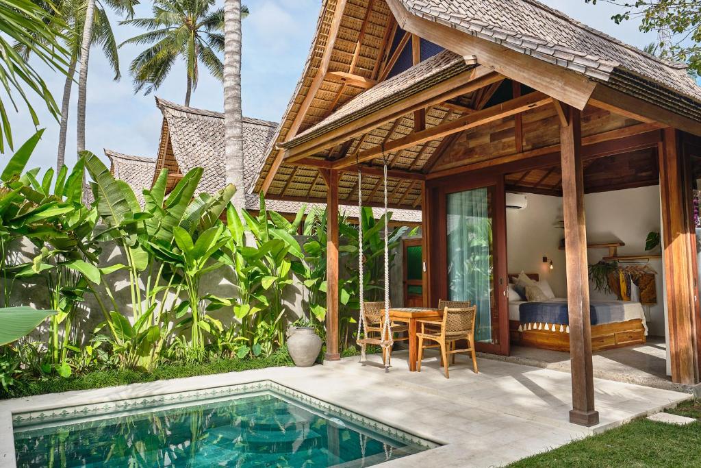 a villa with a swimming pool and a bedroom at Jati Kuta Lombok in Kuta Lombok