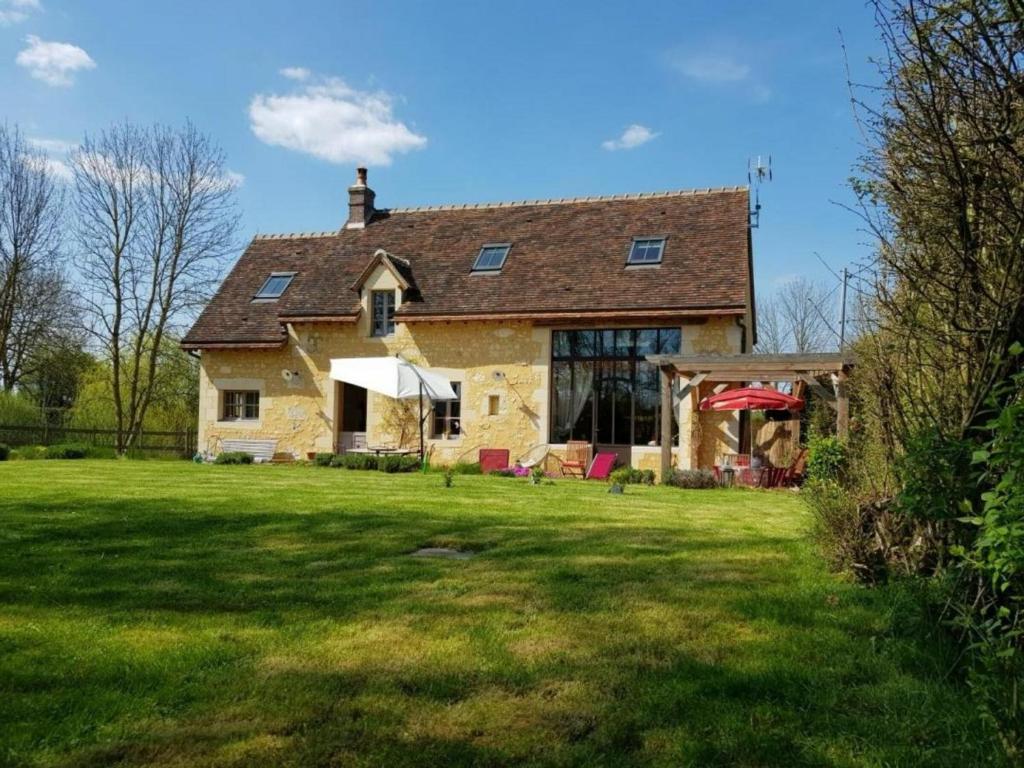 ein altes Steinhaus mit Rasen davor in der Unterkunft Gîte Le Pin-la-Garenne, 4 pièces, 8 personnes - FR-1-497-158 in Le Pin-la-Garenne