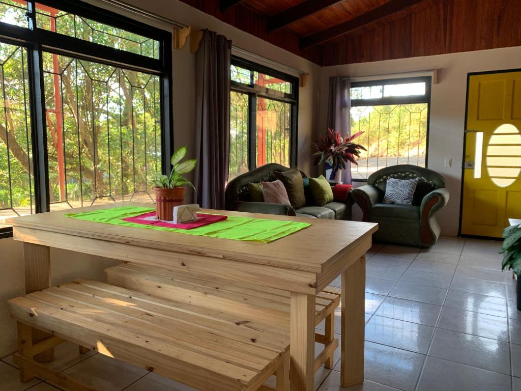 sala de estar con mesa de madera y sillas en Hakuna Matata Guest House en Monteverde