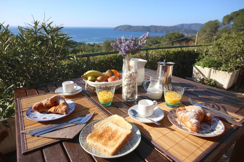 una mesa de madera con pan y fruta. en Ca' La Stella Sea-view Apartments en Porto Azzurro