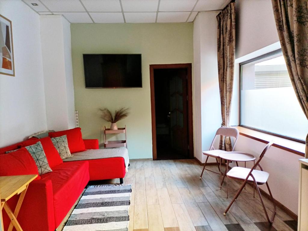 - un salon avec un canapé rouge et une fenêtre dans l'établissement LUTA STUDIO, à Bucarest