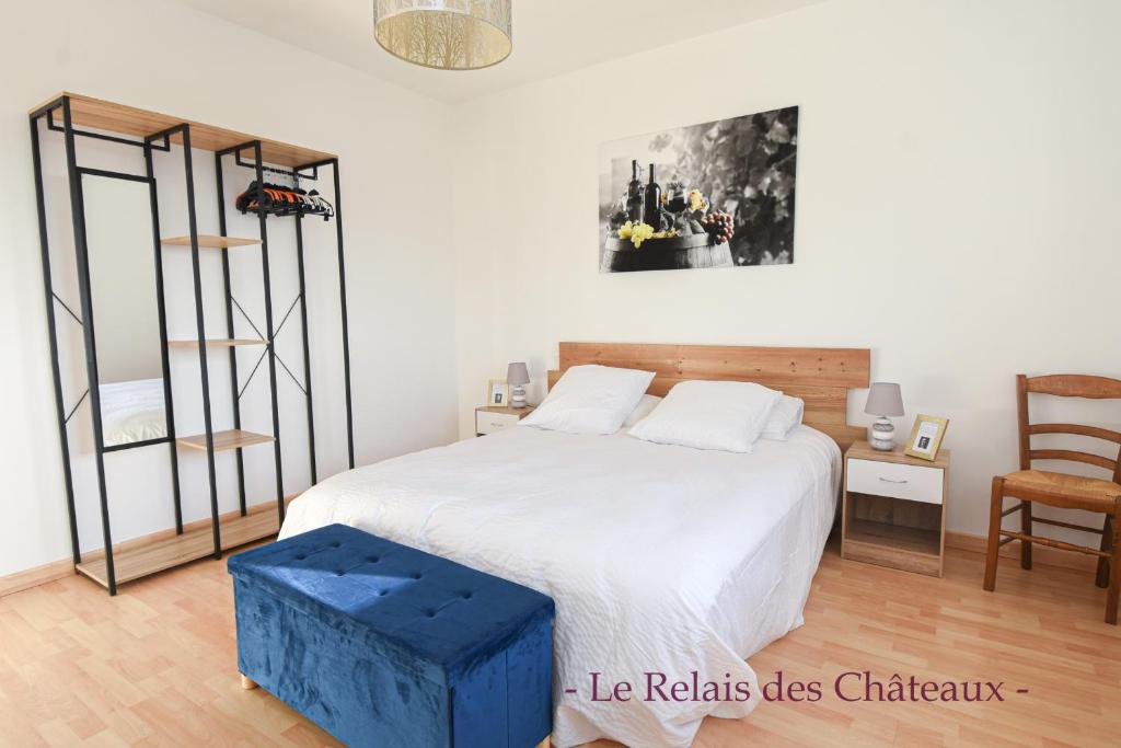 - une chambre avec un grand lit et un tabouret bleu dans l'établissement LE RELAIS DES CHATEAUX, à Margaux