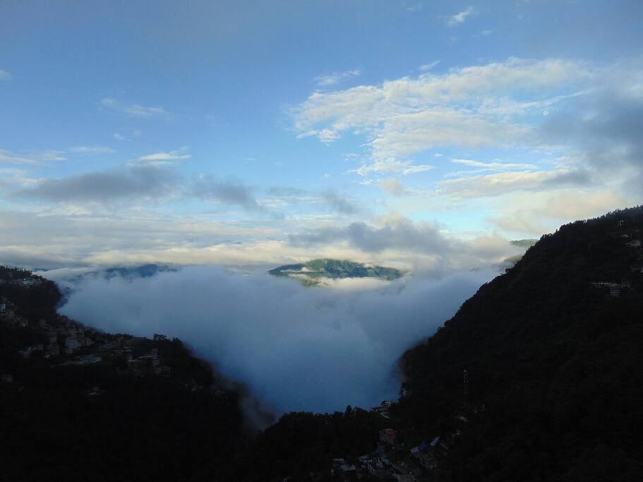 a view of a valley of clouds in the mountains at BOJO House in Gangtok