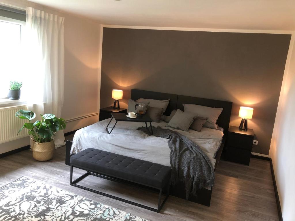 a bedroom with a large bed with a black headboard at Wesermarsch, Apartment mit zwei Schlafzimmern, Gästehaus, Stedinger Landhotel in Berne