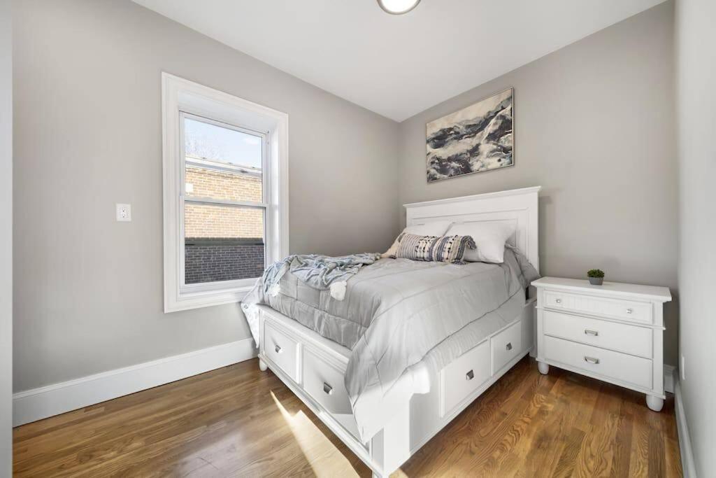 a white bedroom with a bed and a window at Cozy 4BR 2BH Apt In Near BU in Boston