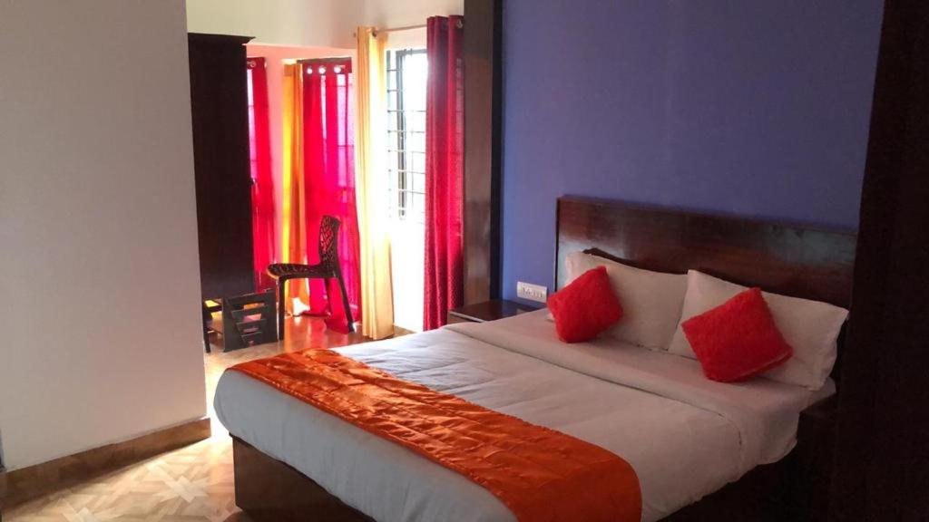1 dormitorio con 1 cama con 2 almohadas rojas en MUNNAR TENT HILLS RESORT, en Devikolam