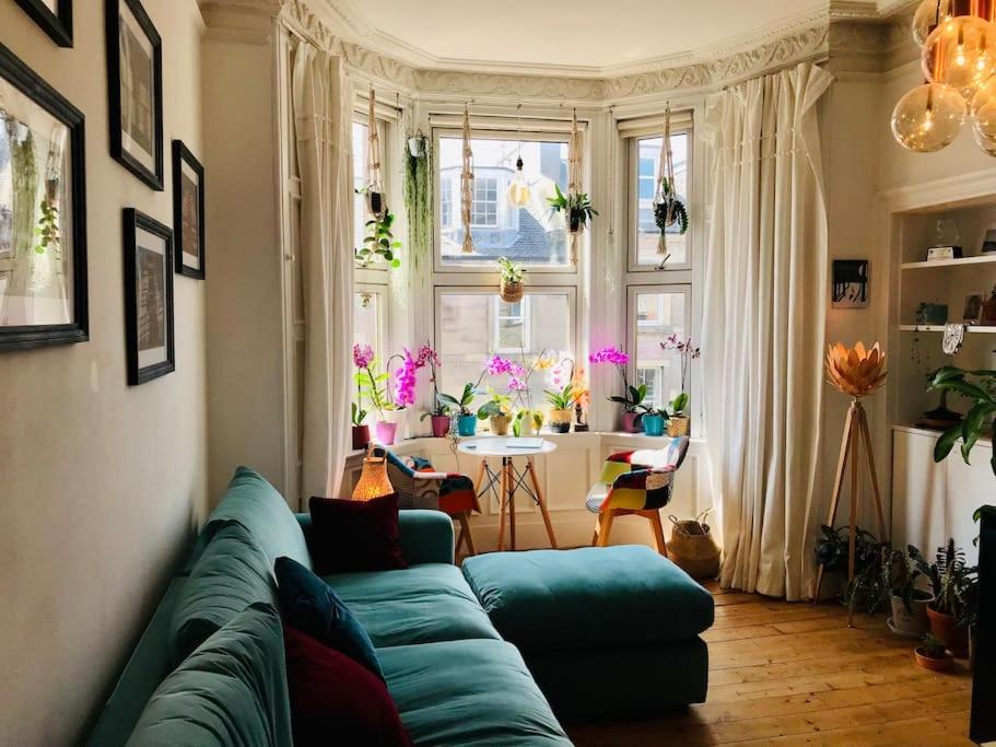 a living room with a blue couch and a table at Cosy 2 Bedroom Flat in Edinburgh in Edinburgh