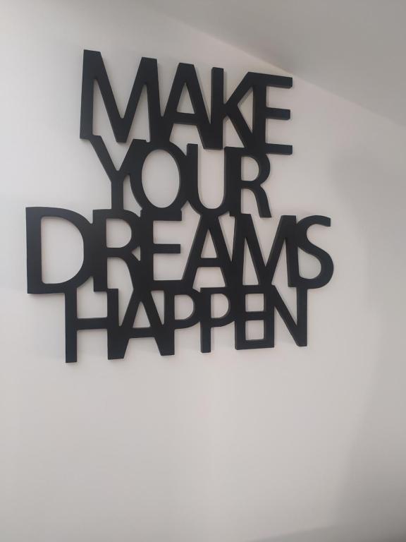 Una señal que dice que hagas que tus sueños ocurran en una pared en Sweet Dream Loft en Verona