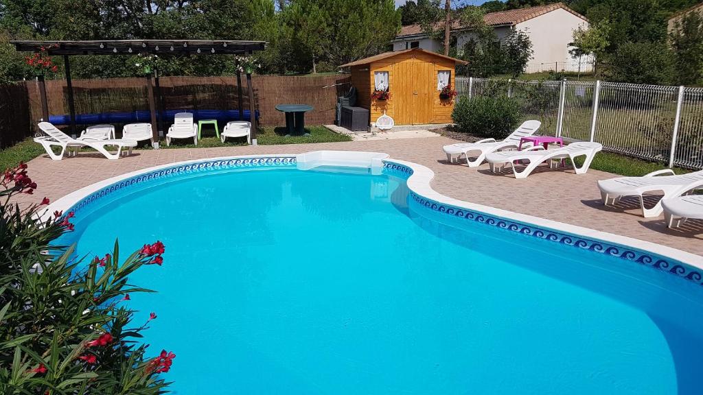 una piscina con sillas, una mesa y una parrilla en Gite Pourquoi Pas, en Montégut-Lauragais