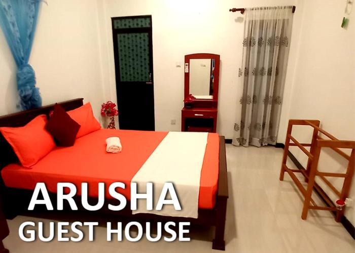 ein Schlafzimmer in der Pension mit einem Bett und einem Spiegel in der Unterkunft Arusha Guest House in Negombo