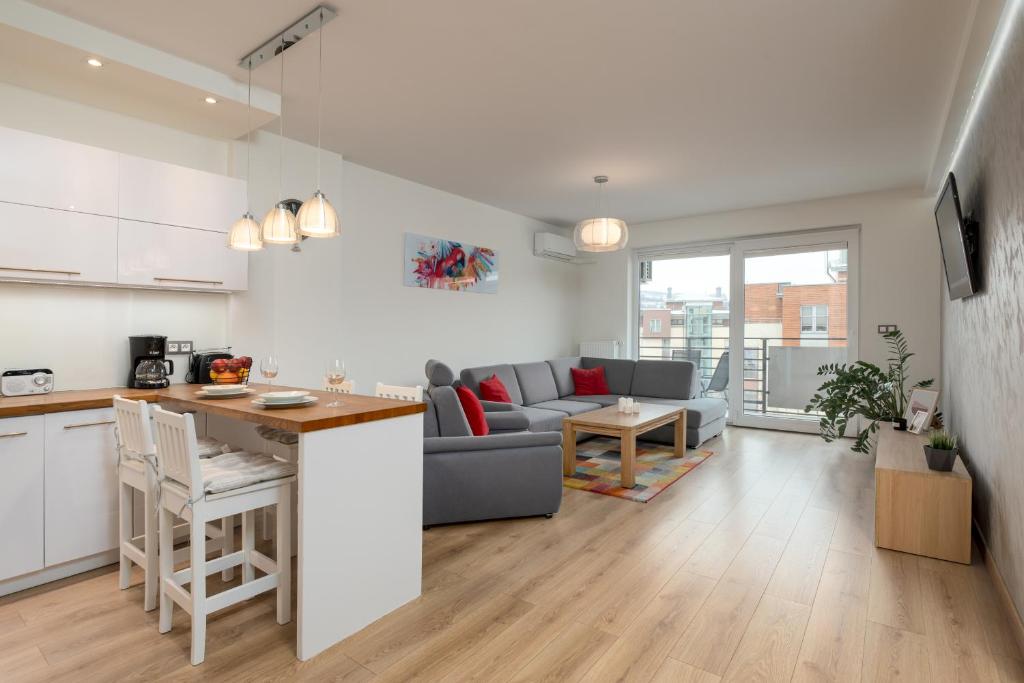 cocina y sala de estar con sofá y mesa en Apartament 14ka. Ustroń, en Ustroń