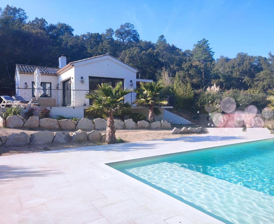 a house and a swimming pool in front of a house at Villa les trois J in Grimaud