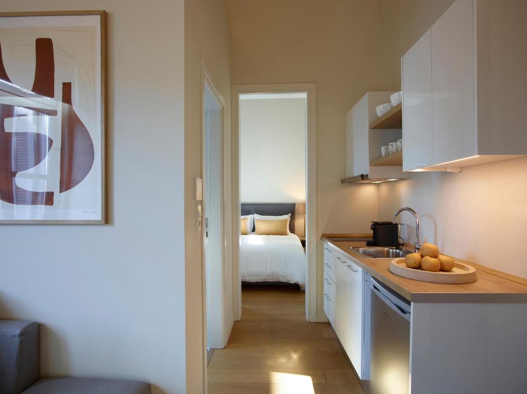 a kitchen with a sink and a room with a bed at Del Taso 1850 in Athens