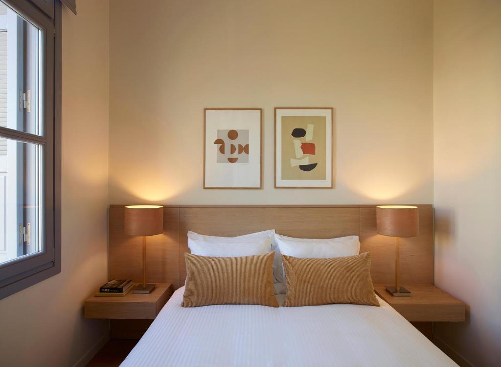 a bedroom with a white bed with two lamps at Del Taso 1850 in Athens