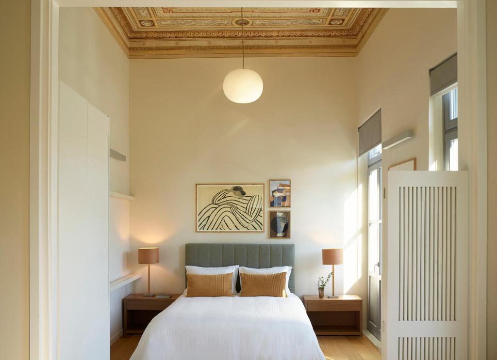 a bedroom with a white bed and a ceiling at Del Taso 1850 in Athens