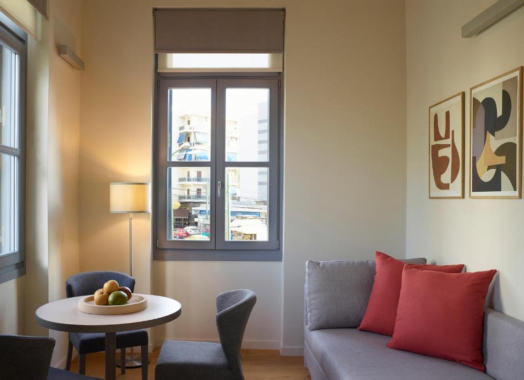 a living room with a couch and a table and a window at Del Taso 1850 in Athens