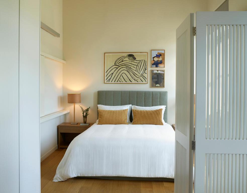 a bedroom with a white bed with a blue headboard at Del Taso 1850 in Athens