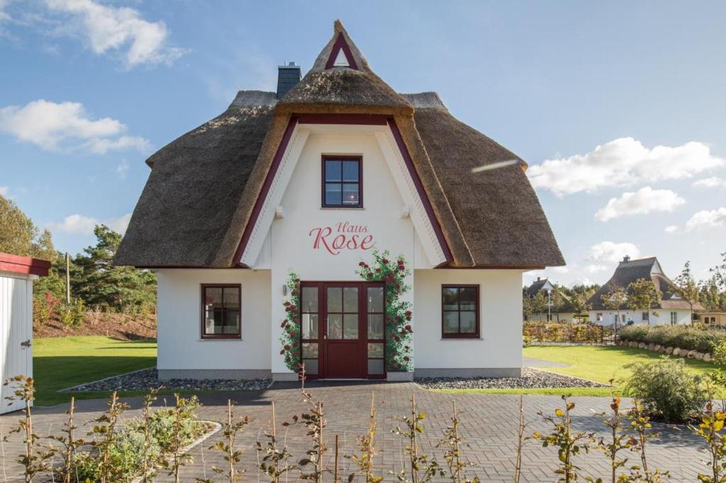 een klein huis met een rieten dak bij Haus Rose, Luxus-Ferienhaus in Fuhlendorf fur 4 Personen in Fuhlendorf