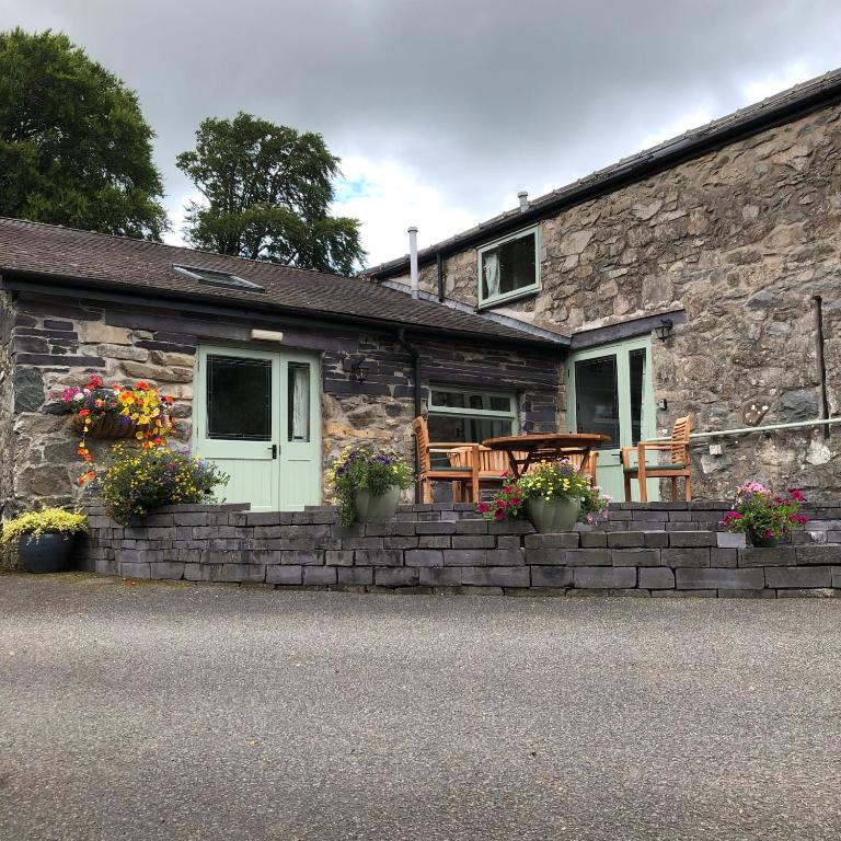 a stone cottage with a table and chairs in front of it at Hafan Cottage at Bryn Llys in Bethesda