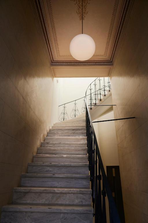 a staircase in a building with a chandelier at Del Taso 1850 in Athens