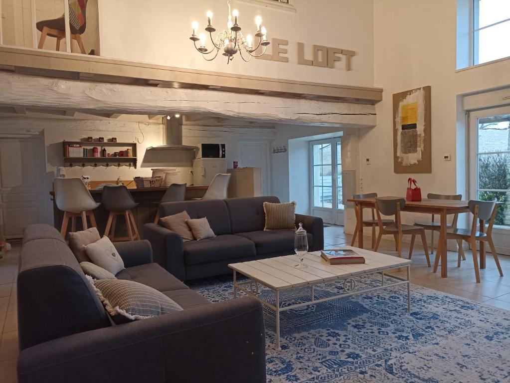 Le Pin-Saint-DenisGîte de charme dans ancienne seigneurie的带沙发和桌子的客厅以及厨房。