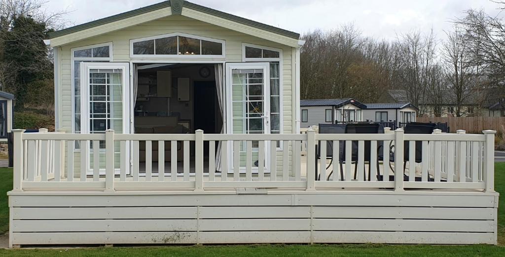 a white screened in porch with a white fence at Caravan in the Cotswolds in Cirencester