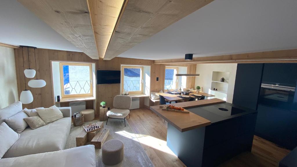 a living room with a white couch and a kitchen at L’alpazo St-Luc in Saint-Luc