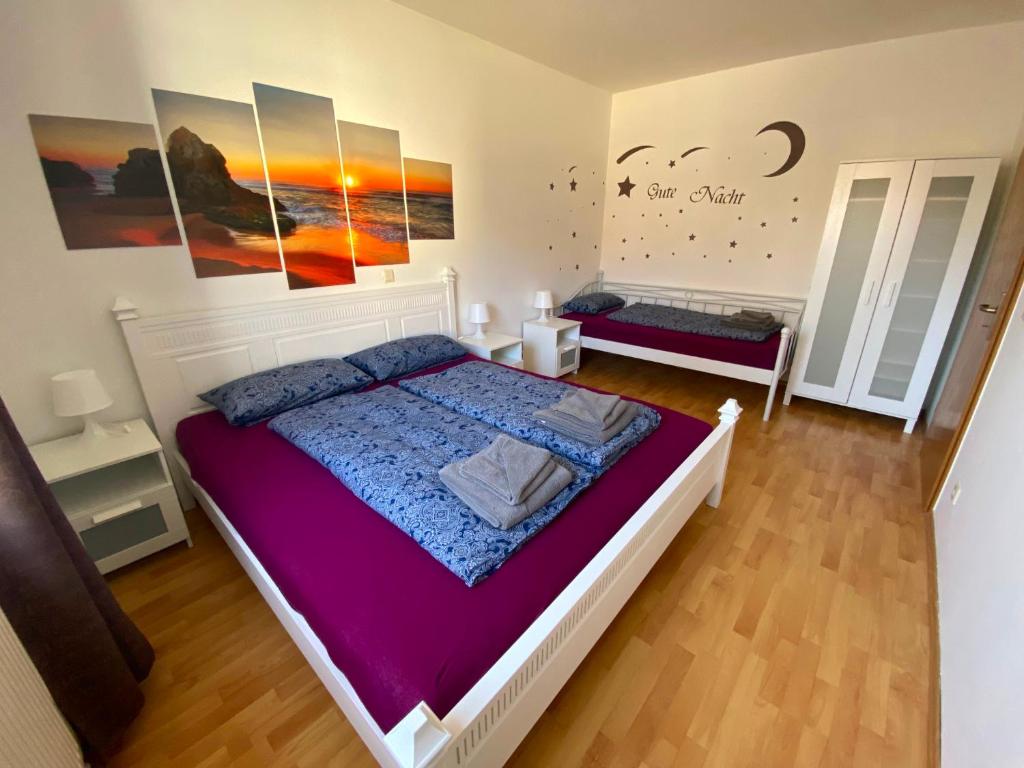 1 dormitorio con 1 cama grande con sábanas moradas en Ferienwohnung Greiz, en Greiz