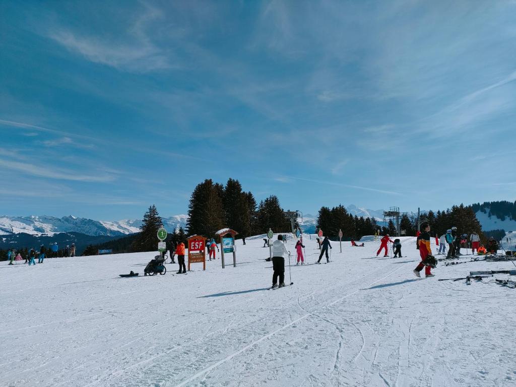 a group of people skiing on a snow covered slope at Studio au pied des pistes- Le Praz de Lys in Taninges