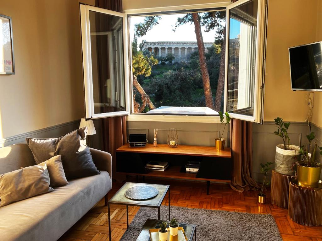 a living room with a couch and a large window at Live Life Acropolis in Athens