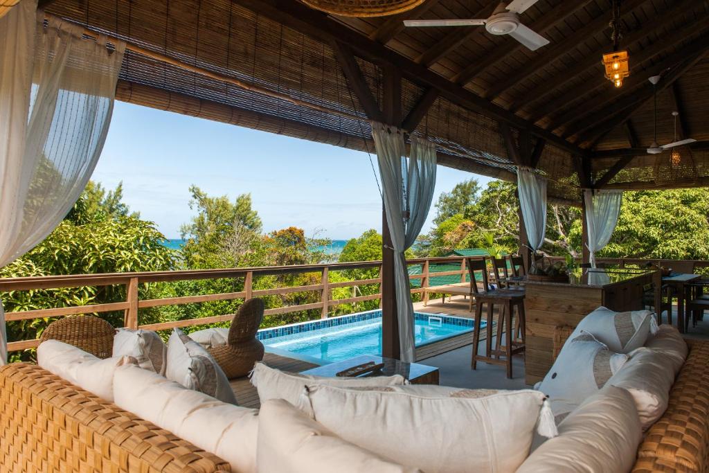a living room with a couch and a swimming pool at La Pointe Beach Huts in Anse Possession