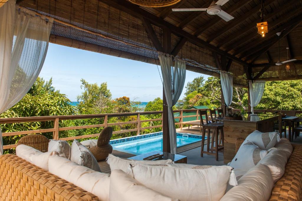 - un salon avec un canapé et une piscine dans l'établissement La Pointe Beach Huts, à Praslin