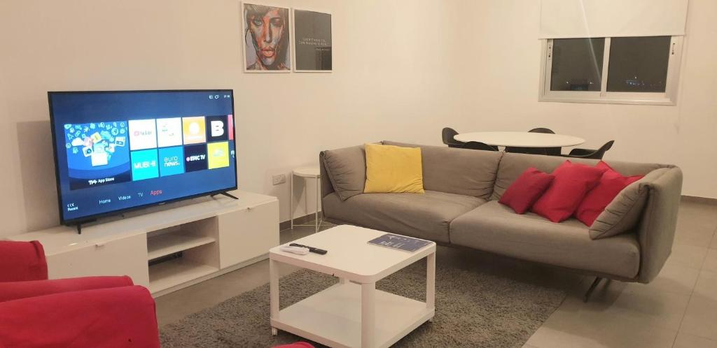 a living room with a couch and a flat screen tv at SUPERLA LUXURY APARTMENT (BREAKBOOKING-CY) in Limassol