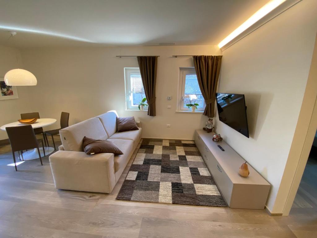 uma sala de estar com um sofá e uma televisão em Emilius Suite em Aosta