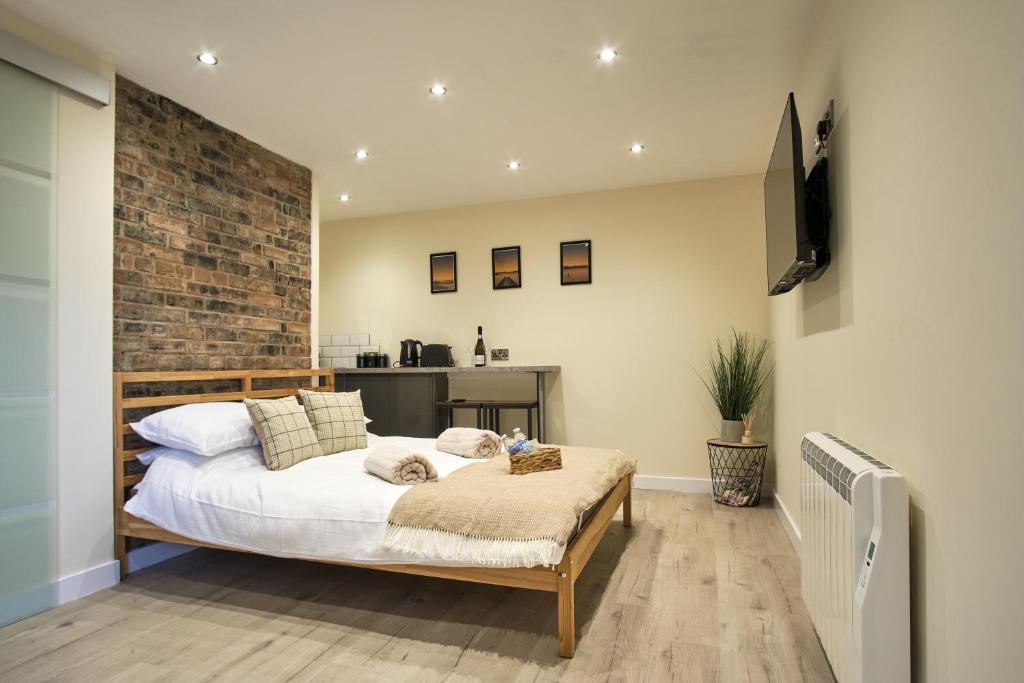 a bedroom with a bed and a brick wall at Seòmar Beag in Oban