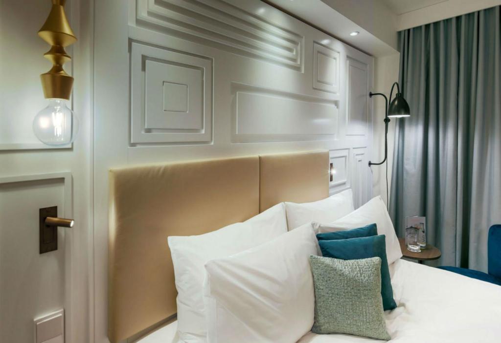 a bedroom with a white bed with pillows on it at Hotel Indigo Dresden - Wettiner Platz by IHG in Dresden
