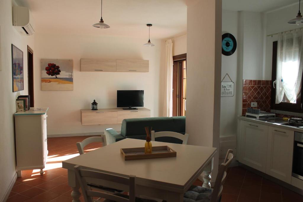 a living room with a table and a kitchen at sweet home la maddalena in La Maddalena