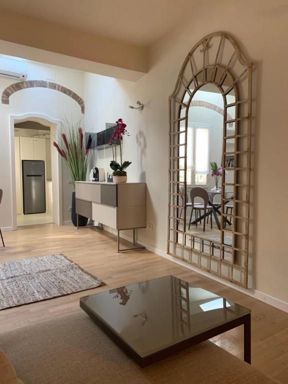 a living room with a table and a mirror at Maison del Ducato Cavour 37 in Parma