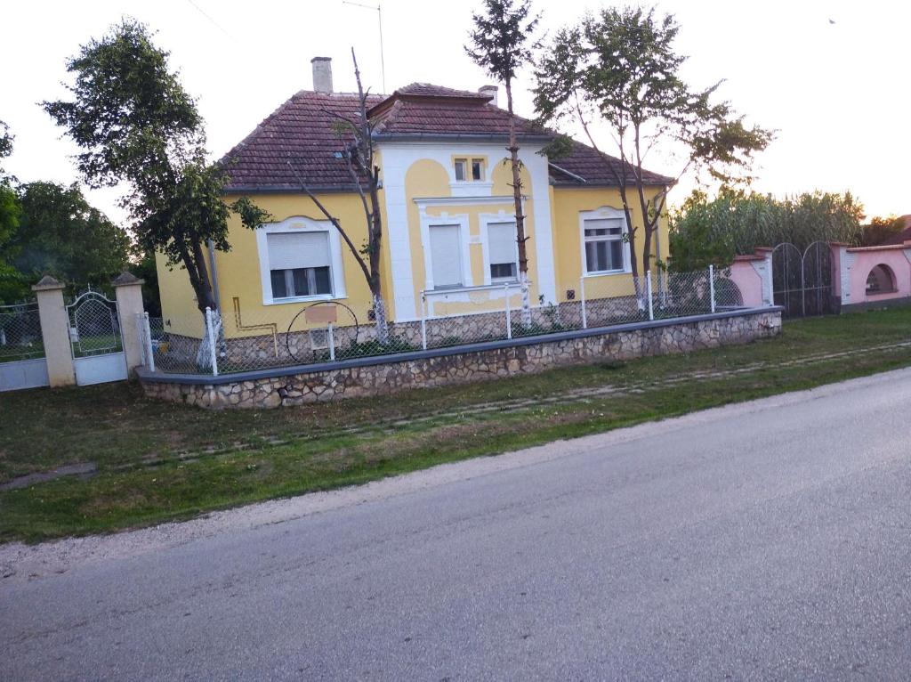 una casa amarilla al lado de una carretera en 8513 Mihályháza - Rózsi Vendégház, en Mihályháza