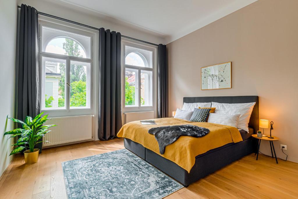 Kaizl Park Residence في براغ: غرفة نوم بسرير ونوافذ