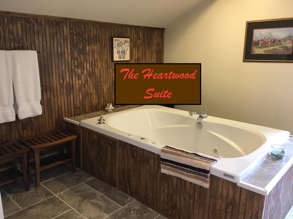 a bath tub with a sign that reads the magnificent suite at Oak Valley Inn and Suites in Geneseo