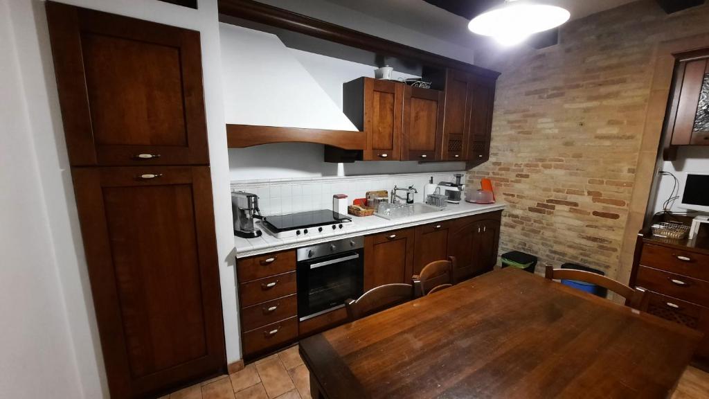 kuchnia z drewnianymi szafkami i drewnianym stołem z drewnianym stołem w obiekcie Appartamento country relax w mieście Montelupone